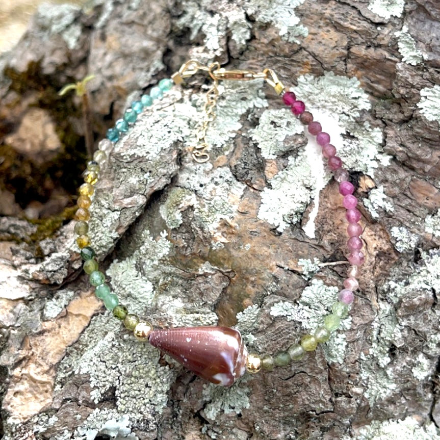 Bracelet with a single Purple Hawaiian shell and rainbow tourmaline gemstone with 14 karat gold filled clasp.